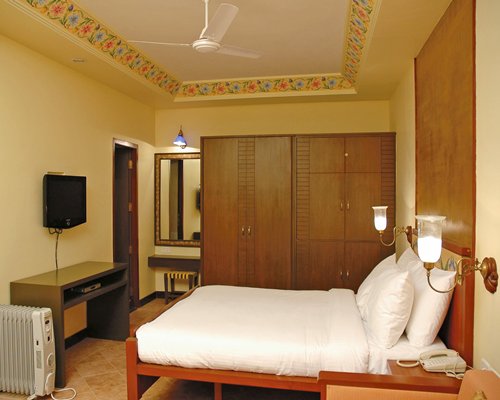 A well furnished bedroom with a television.
