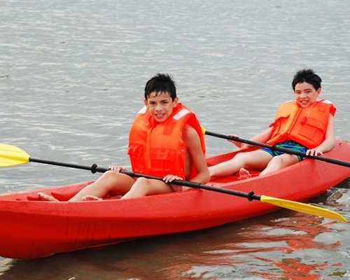 View of the kids in a kayaking boat on the beach.