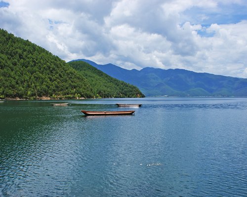 View of the lake with the boats alongside the mountains.