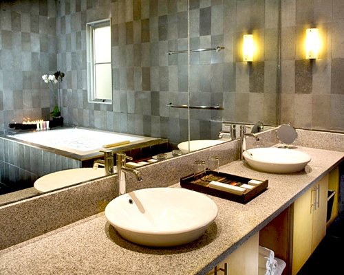 A bathroom with bathtub and double sink vanity.