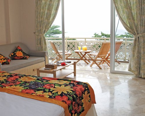 A well furnished bedroom with a balcony.