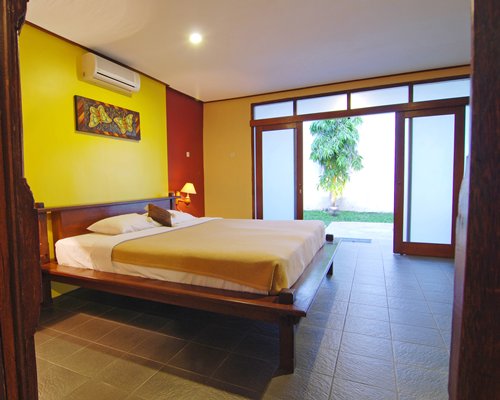 A well furnished bedroom with a king bed and outside view.