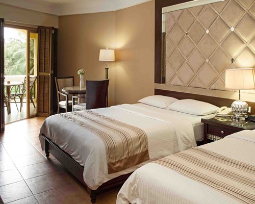 A well furnished bedroom with two beds and an outside view.