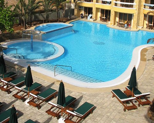 An outdoor swimming pool with chaise lounge chairs.