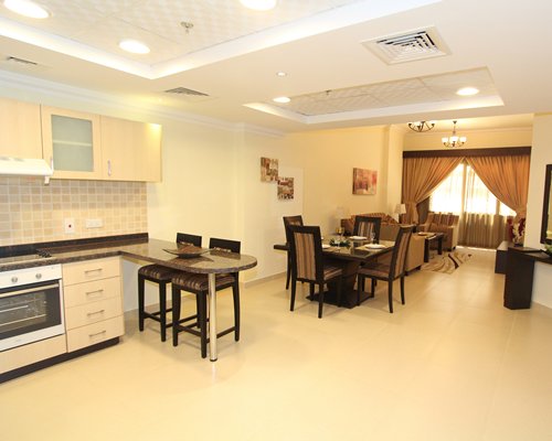 An open plan kitchen with living room dining area and breakfast bar.