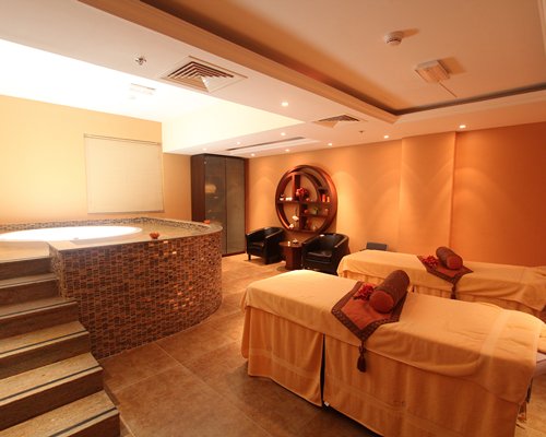 A well furnished indoor spa with hot tub.