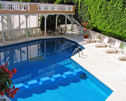 An outdoor swimming pool with chaise lounge chairs.