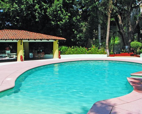 Outdoor swimming pool with covered outdoor dining.