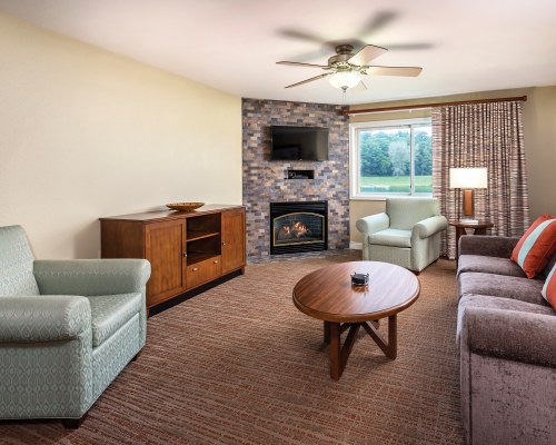 A WELL FURNISHED LIVING ROOM WITH TELEVISION AND FIREPLACE.