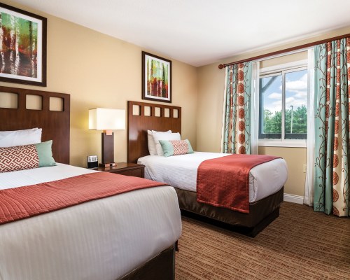 A WELL FURNISHED BEDROOM WITH TWO TWIN BEDS AND AN OUTSIDE VIEW.