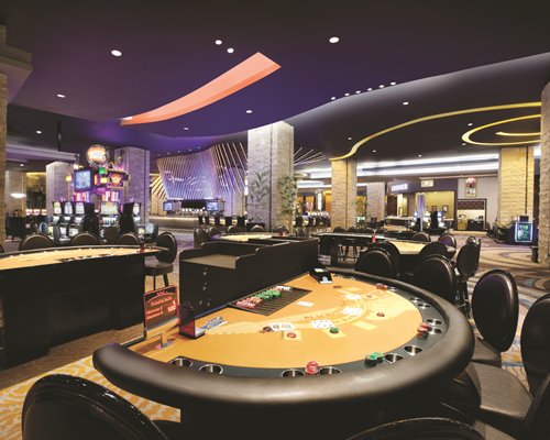 Indoor recreation room with casino tables and arcade games.