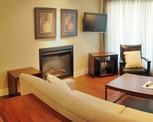 A well furnished living room with a television fireplace and outside view.
