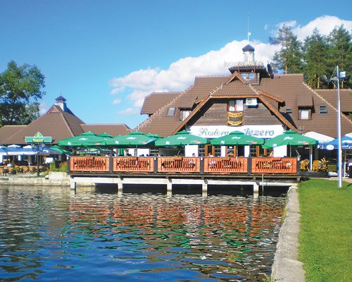 An outdoor restaurant with sunshades alongside the water.