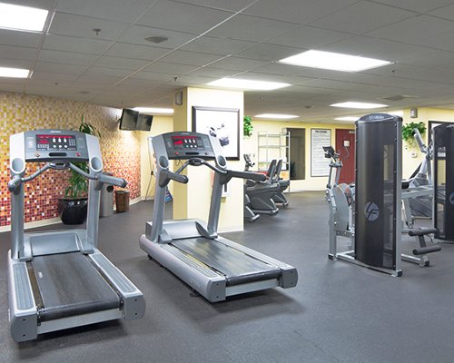 A well equipped fitness center with television.