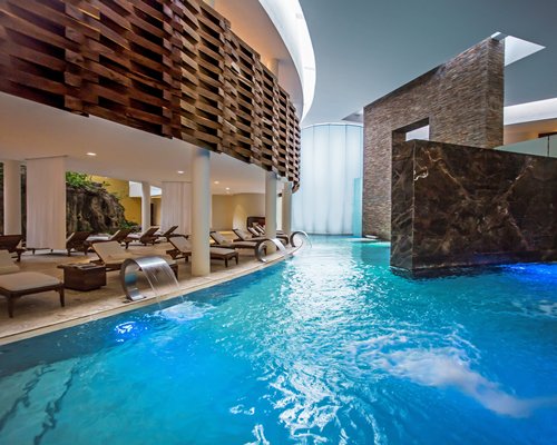 Indoor swimming pool with chaise lounge chairs.