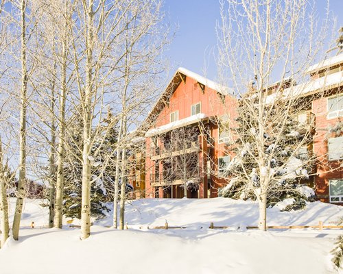 An exterior view of multi story resort units covered in snow.