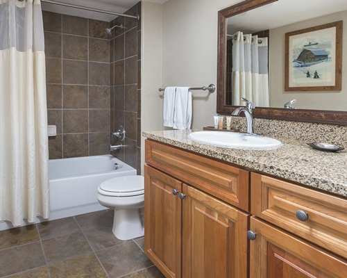 A bathroom with a closed sink vanity bathtub and shower.