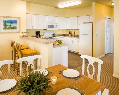 AN OPEN PLAN DINING AND KITCHEN AREA WITH A BREAKFAST BAR.
