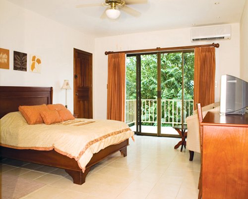 A well furnished bedroom with a television and a balcony.