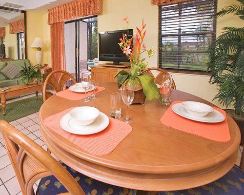 A well furnished living room with television dining area and patio.