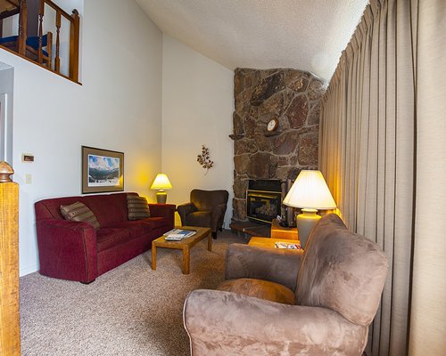 A well furnished living room with a pull out sofa and fireplace.