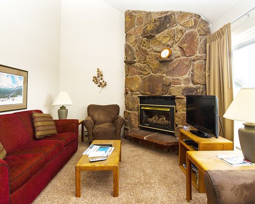 A well furnished living room with television and fireplace.