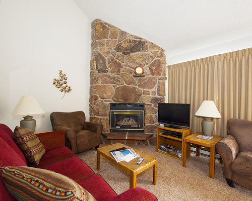 A well furnished living room with fireplace and television.