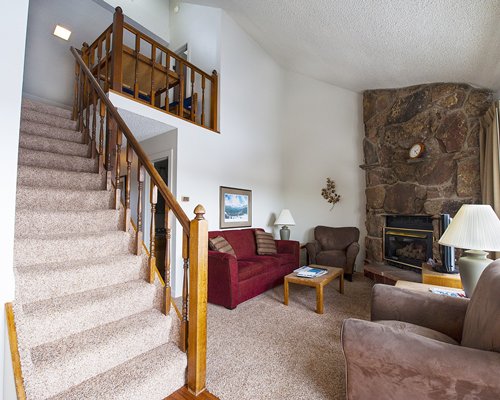 A well furnished living room with a fireplace and staircase.