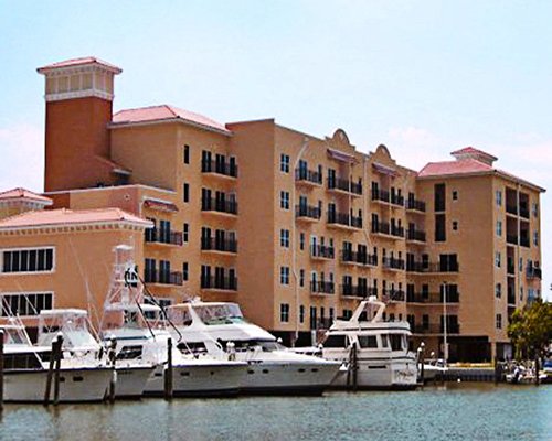 View of multiple unit balconies alongside the ocean with marina.
