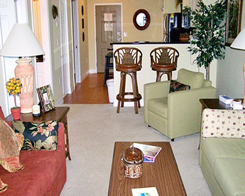 A well furnished living room with open plan kitchen and breakfast bar.