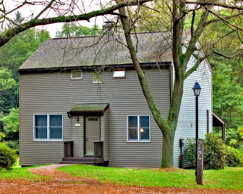AN EXTERIOR VIEW OF A RESORT UNIT SURROUNDED BY TREES.