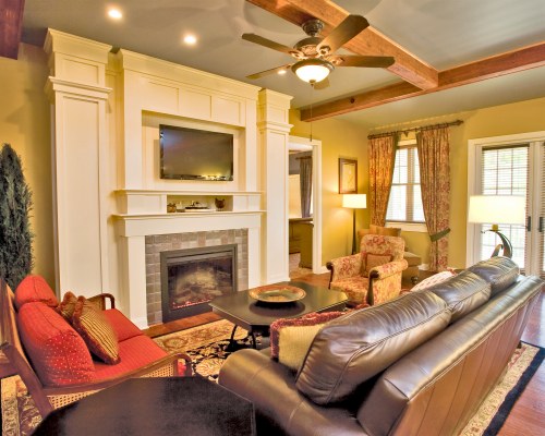 A WELL FURNISHED LIVING ROOM WITH A TELEVISION AND FIREPLACE.