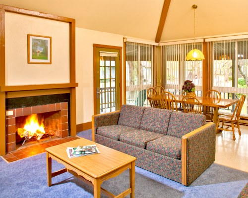 AN OPEN PLAN LIVING AND DINING AREA WITH A FIREPLACE.
