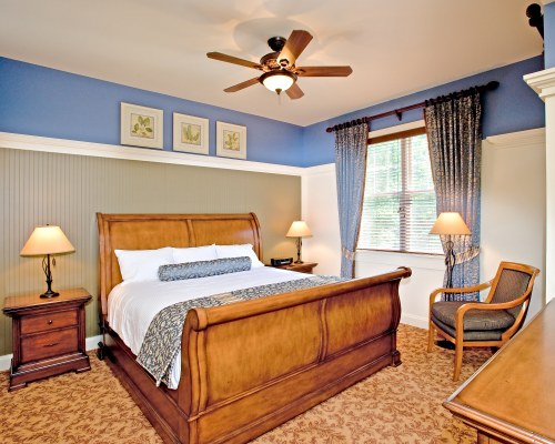 A WELL FURNISHED BEDROOM WITH AN OUTSIDE VIEW.