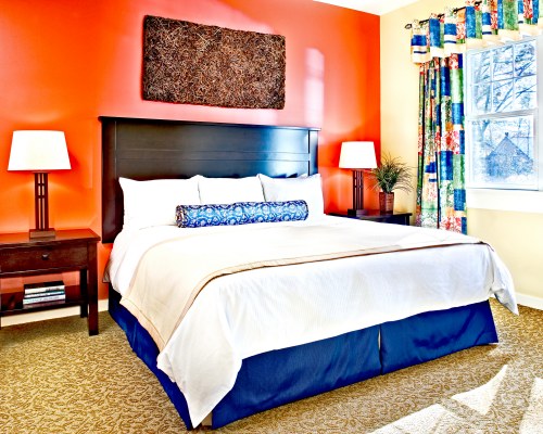 A WELL FURNISHED BEDROOM WITH A KING BED.