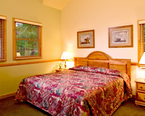 A WELL FURNISHED BEDROOM WITH KING BED AND OUTSIDE VIEW.
