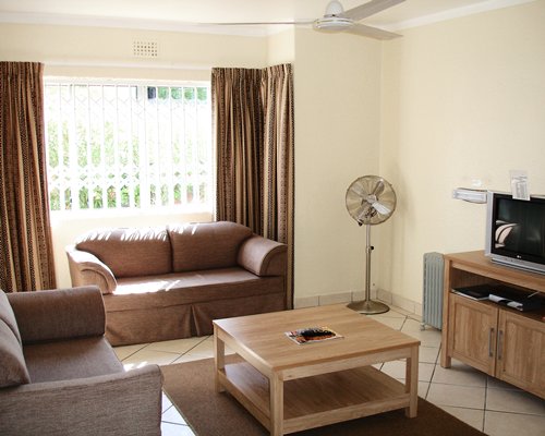A well furnished living room with a television double pull out sofa and an outside view.