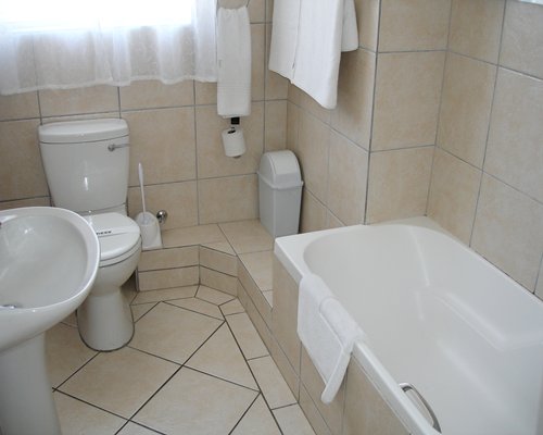A bathroom with bathtub shower and single sink.