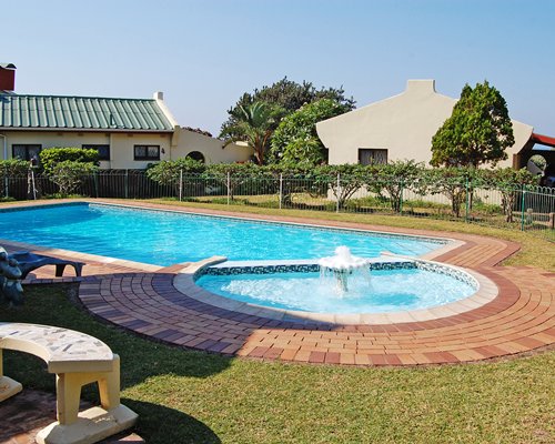 An outdoor pool with the water fountain alongside the resort units.