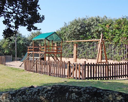 Outdoor picnic area with kids playscape.