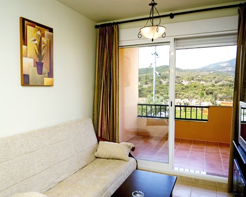 A well furnished living room with a television and a balcony.