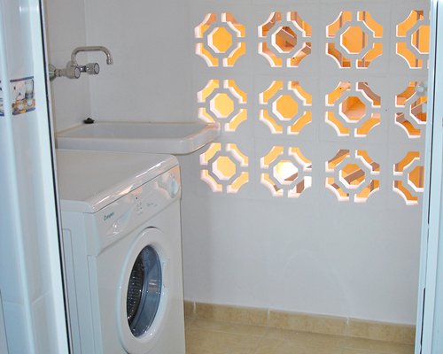 A laundry room with washing machine and sink.