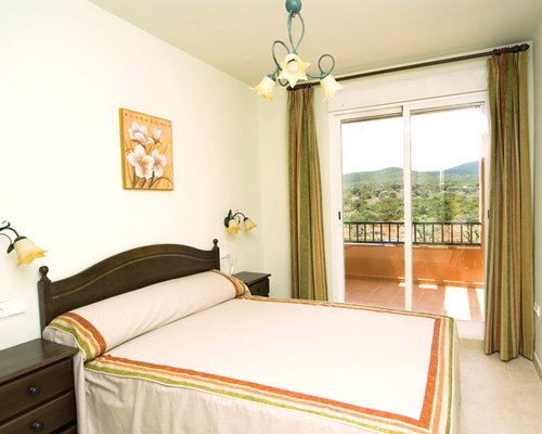 A well furnished bedroom with a balcony.