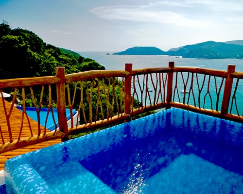 A view of an outdoor hot tub alongside the ocean.