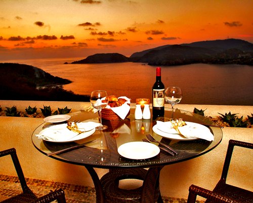 An outdoor dining area with the ocean view at dusk.