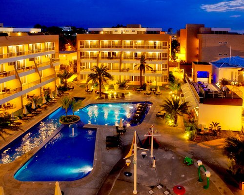 An exterior view of outdoor swimming pool alongside multi story units.