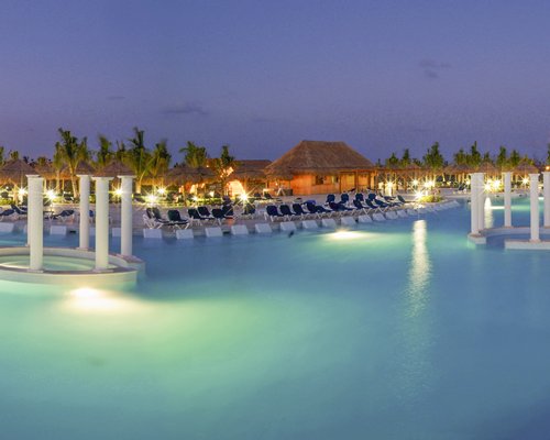 A large outdoor swimming pool with chaise lounge chairs alongside the resort unit.