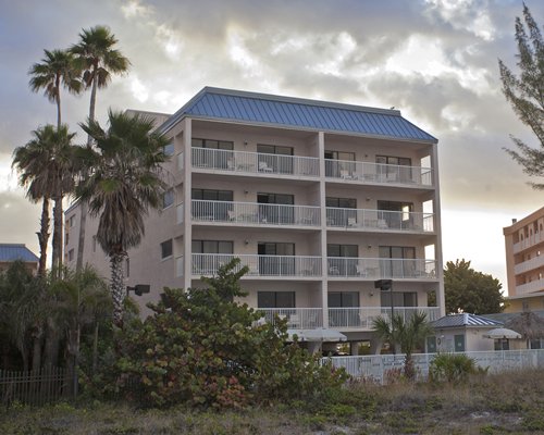 An exterior view of a multi story resort unit alongside trees.