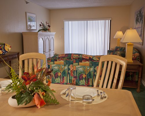 A well furnished living room with a dining area and an outside view.