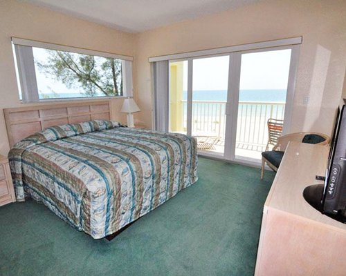 A well furnished bedroom with a television and a patio.